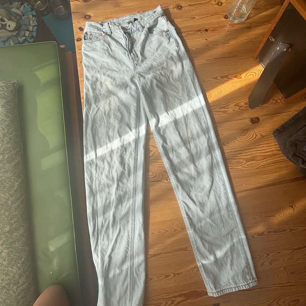 American Eagle light wash blue jeans high waisted crossover, small stain on leg.